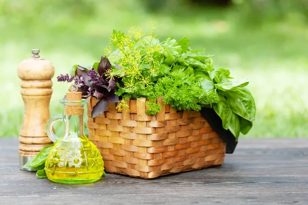 Verschiedene Kräuter Korb Olivenöl Und Pfeffer Auf Dem Gartentisch — Stockfoto