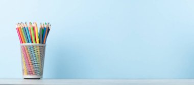 Renkli kalemler. Ofis malzemeleri ya da okul malzemeleri mavi duvarın önünde metin için fotokopi alanı ile
