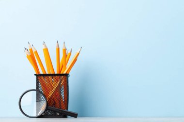 Ofis malzemeleri ya da okul malzemeleri mavi duvarın önünde metin için fotokopi alanı ile