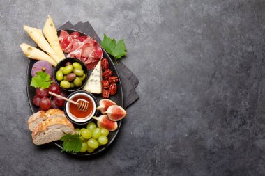 Prosciutto, peynir, incir ve üzümlü Antipasto tabağı. Aperatif kurulu. Üst görünüm düzlüğü kopyalama alanı ile yatıyordu