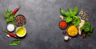 Koyu taş masadaki çeşitli baharatlar, otlar ve baharatlar. Hint mutfağı. Üst görünüm düzlüğü kopyalama alanı ile yatıyordu