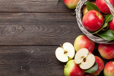 Tahta masadaki sepetin içinde olgun meyve bahçeleri. Üst görünüm düzlüğü kopyalama alanı ile yatıyordu