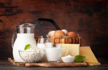 Çeşitli süt ürünleri. Süt, peynir, kulübe, ekşi krema ve yumurta. Ahşap arka planda