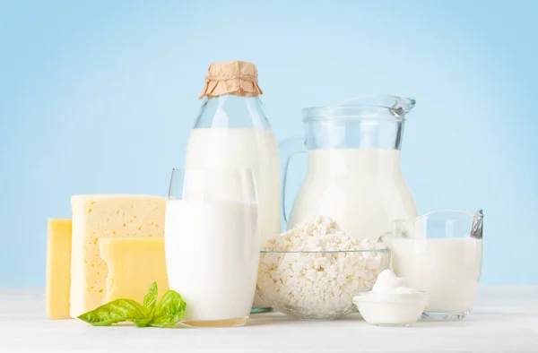 Różne Produkty Mleczne Mleko Ser Domek Śmietana Przed Niebieskim Tłem — Zdjęcie stockowe
