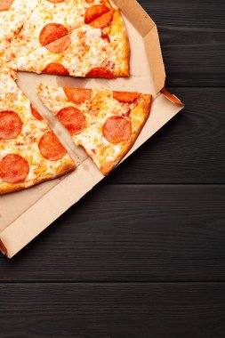 Kutusunda salam olan lezzetli biberli pizza. Kopyalama alanı olan üst görünüm. Düz yatıyordu