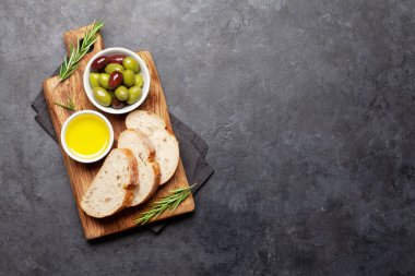 Olgun zeytin, zeytinyağı ve ciabatta ekmeği. Üst görünüm düzlüğü kopyalama alanı ile yatıyordu