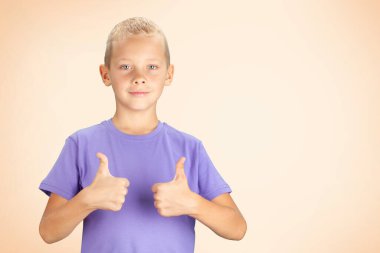 Baş parmağını kaldıran komik çocuk. Kopyalama alanı olan mor arkaplan