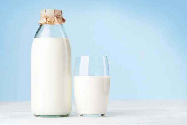 Mjölk Glasflaska Och Kopp Framför Blå Bakgrund Med Kopieringsutrymme — Stockfoto