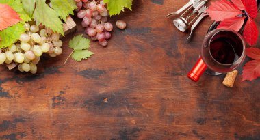 Ahşap masada kırmızı şarap ve üzüm. Üst görünüm düzlüğü kopyalama alanı ile yatıyordu