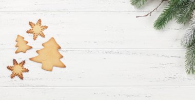 Noel tebrik kartı, köknar ağacı ve ahşap arka planda zencefilli kurabiye. Üst görünüm düzlüğü Xmas selamlamalarınız için boşluk ile yatar