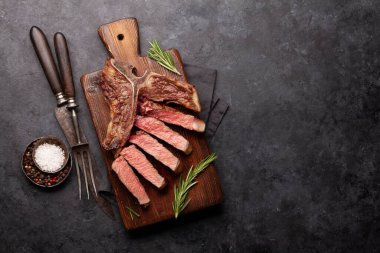 T-bone grilled beef steak with spices and herbs. Top view flat lay with copy space clipart