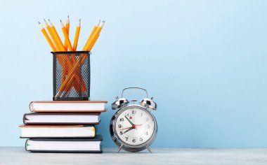 Ofis not defteri malzemeleri ve okul kitapları mavi duvarın önünde metnin için fotokopi alanı ile birlikte.