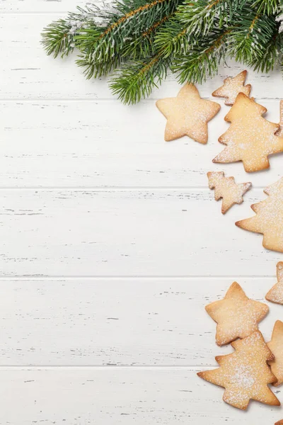 クリスマスジンジャーブレッドクッキーと木製の背景の上のクリスマスモミの木の枝 挨拶のためのスペース付きのトップビュー — ストック写真