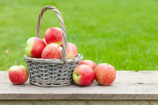 コピースペース付き木製屋外テーブルのバスケットに熟した庭のリンゴの果物 — ストック写真
