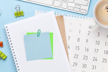 İş masası iş yeri ve ofis eşyaları mavi arka planda. Üstteki görünüm düzlüğü metin için kopyalama alanı ile yatıyordu