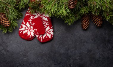 Noel tebrik kartı, köknar ağacı ve taştan arka planda eldivenler ve Noel kutlamalarınız için yer kopyalama kartı. Üst görünüm düzlüğü