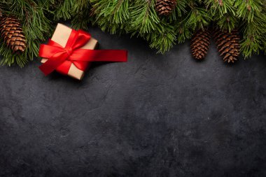 Köknar ağacı ve taştan arka planda hediye kutusu olan Noel tebrik kartı ve yılbaşı kutlamalarınız için alanı kopyalamak. Üst görünüm düzlüğü