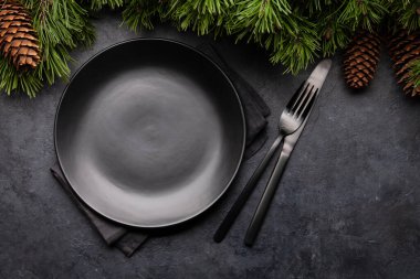 Noel tebrik kartı, köknar ağacı boş tabak, çatal ve bıçak taştan arka planda. Üst görünüm düzlüğü kopyalama alanı ile yatıyordu