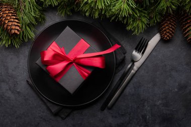 Köknar ağacı, tabak ve hediye kutusuyla dolu Noel tebrik kartı ve yılbaşı kutlamalarınız için alanı kopyalayın. Üst görünüm düzlüğü