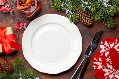 Noel sofrası, boş tabak, hediye kutusu, sıcak şarap ve xmas dekoru. Üst görünüm düzlüğü kopyalama alanı ile yatıyordu