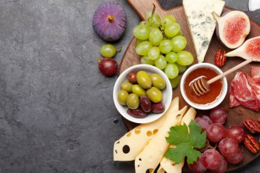 Prosciutto, peynir, incir ve üzümlü Antipasto tabağı. Aperatif kurulu. Üst görünüm düzlüğü kopyalama alanı ile yatıyordu