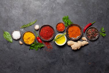 Koyu taş masadaki çeşitli baharatlar, otlar ve baharatlar. Hint mutfağı. Üst görünüm düzlüğü kopyalama alanı ile yatıyordu