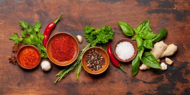 Ahşap masada çeşitli baharatlar, otlar ve baharatlar. Hint mutfağı. Üst görünüm düzlüğü