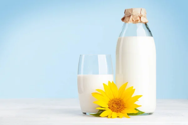 Mleko Szklanej Butelce Filiżance Przed Niebieskim Tłem Przestrzenią Kopiowania — Zdjęcie stockowe