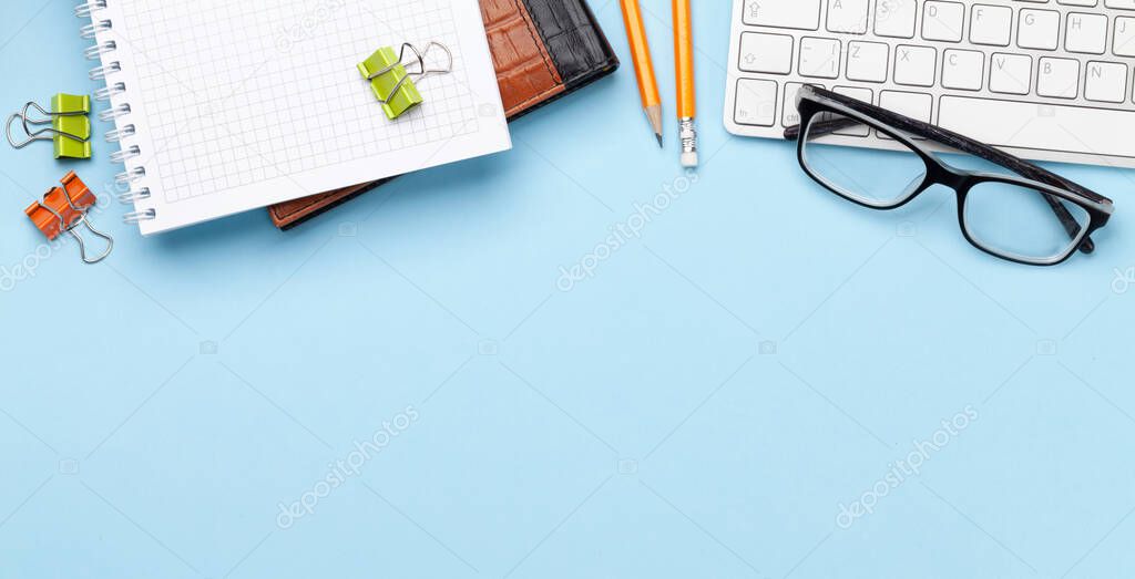 Business desk workplace and office objects over blue backdrop. Top view flat lay with copy space for your text