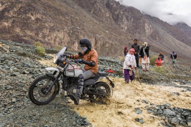Nubra Vadisi, Hindistan - 29 Haziran 2017: Biker geçiş nehir eriyen buzul Himalaya Dağları, Ladakh bölge, Hindistan üzerinden akan