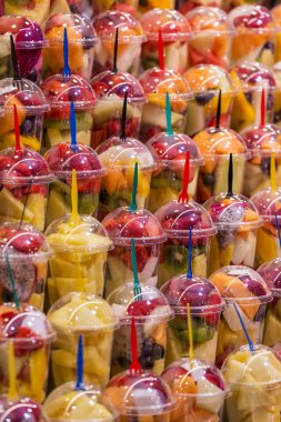 Çeşitli türlü smoothie içmeye hazırlanıyor plastik bardak taze meyve. Renkli meyveli içki ve içecek.