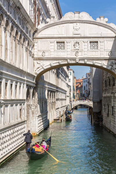 Tourists in gondolas sailing on the Rio de Palazzo o de Canonica Canal under the Bridge of Sighs or Ponte dei Sospiri in Venice, Italy.