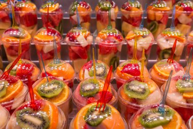 Çeşitli türlü smoothie içmeye hazırlanıyor plastik bardak taze meyve. Renkli meyveli içki ve içecek.