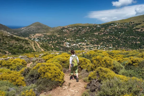 Femme avec un sac à dos randonnée sur un sentier de randonnée sur l'île d'Andros, Grèce — Photo