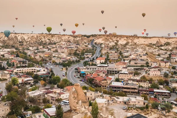 Hete lucht ballon vliegen over Göreme dorp in Cappadocië, Turkije — Stockfoto