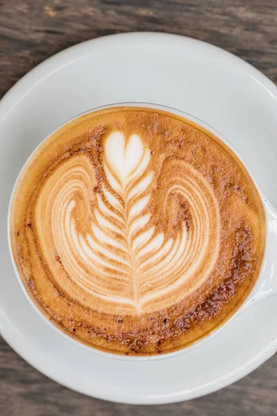 Tasse de café cappuccino avec belle latte art servi sur une table en bois . — Photo