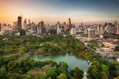 Bangkok şehir merkezinde gün batımında Modern gökdelenler ve Lumpini park