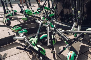 Polonya 'nın Varşova şehrinde kaldırıma bırakılan Lime adlı sürüş paylaşım şirketinin birçok elektrikli scooterı, aracı veya e-scooter' ı var.