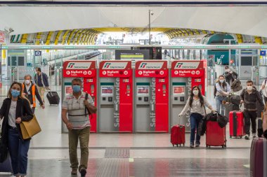 İlaç maskeli kimliği belirsiz yolcu Roma Fiumicino Havaalanı, Roma, İtalya 'daki 3 numaralı terminale doğru yürüyor.