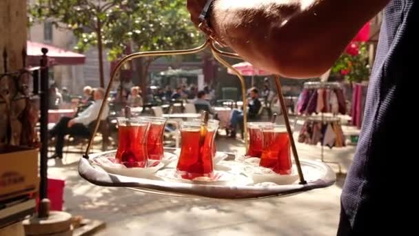 Офіціант приносить традиційний турецький чай на таці. — стокове відео