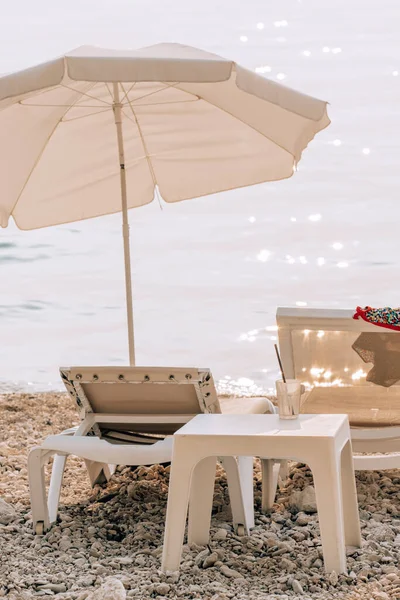 Summer umbrella and sun bed at empty beach — Stock Photo, Image