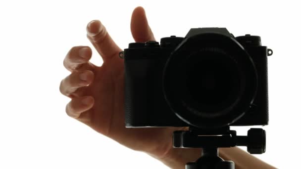 Photographes main tourne autour de l'appareil photo sur un trépied et fait photo — Video