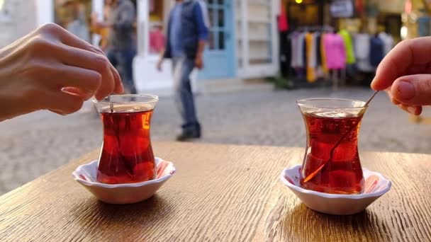 Перемешивание сахара ложкой в стакане турецкого чая в замедленной съемке — стоковое видео