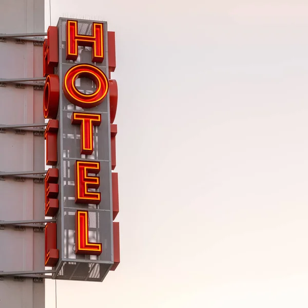 Panneau d'hôtel néon sur le coin du bâtiment contre le ciel couchant — Photo