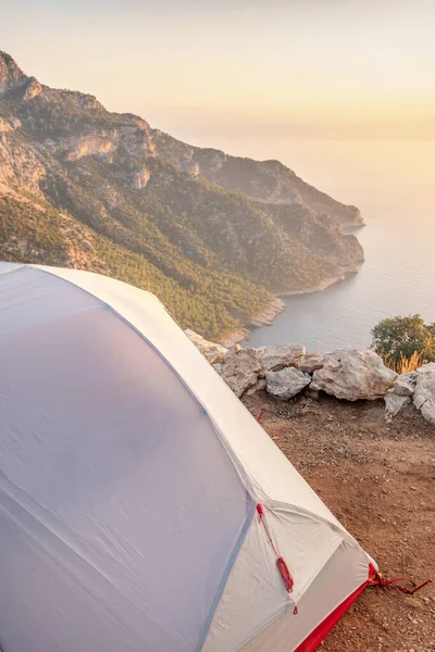 Tenda em um acampamento selvagem nas montanhas ao pôr do sol — Fotografia de Stock