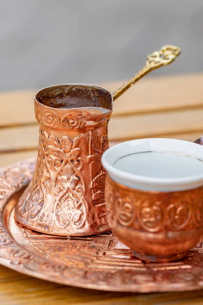 Café bosnien noir traditionnel dans un magnifique cezve en cuivre à table en bois — Photo