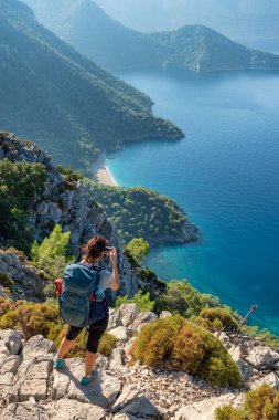 Türkiye 'nin Antalya kenti yakınlarındaki Akdeniz kıyılarının güzel manzarasının fotoğrafını çeken genç kadın.