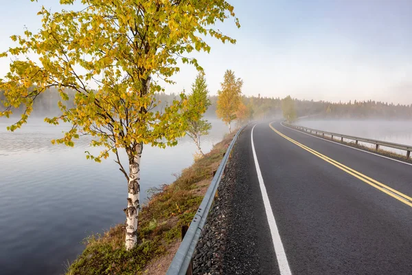Paisagem finlandesa com estrada estreita de carro através do lago. — Fotografia de Stock