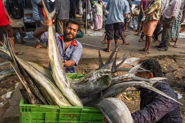 Indyjski rybak niesie pudełko z rybami na targu rybnym w Fort Kochi, Indie — Zdjęcie stockowe