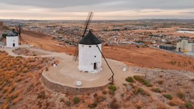 Günbatımında Consuegra 'nın tarihi yel değirmenlerinin havadan görünüşü, Castilla-La Mancha, İspanya. Akşam ışığında tepelerde Don Kişot 'un eski tarihi yel değirmenleri. Molinos de Viento de Consuegra